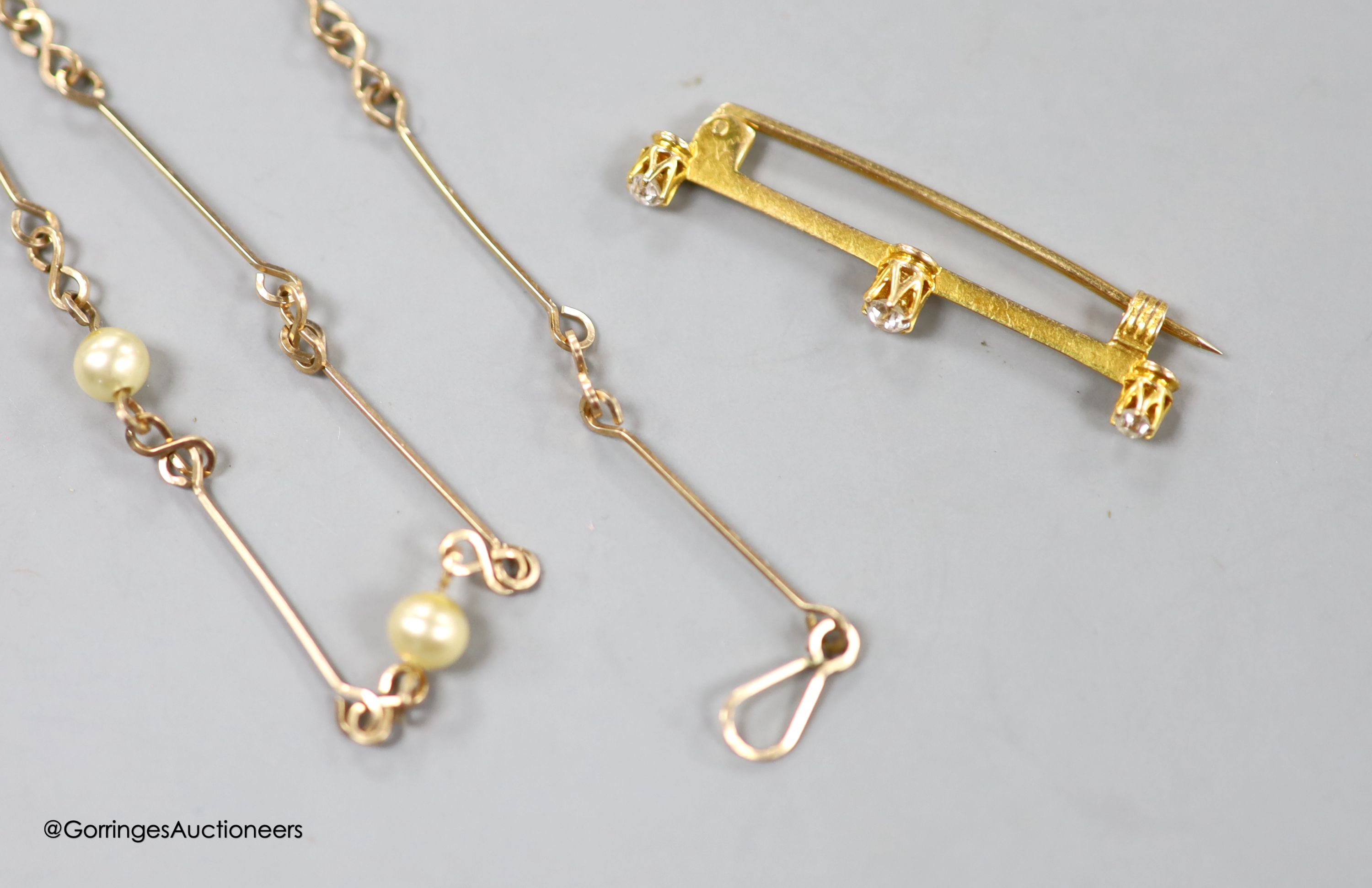 An early 20th century yellow metal and three stone diamond set bar brooch, 36mm, gross 1.6 grams and a yellow metal and simulated pearl set neck chain, 47cm, gross3.8 grams.